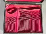 une boîte rouge contenant un ensemble d'ustensiles en plastique