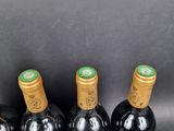 four bottles of wine are lined up in a row on a table