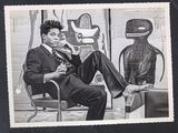 photographie en noir et blanc d'un homme en costume assis sur une chaise à côté d'un robot