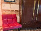 une chaise rouge placée devant une armoire en bois