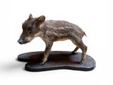 figurine représentant un sanglier, posée sur un socle en bois
