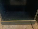 a black oven sitting on a wooden floor in a kitchen