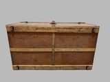 an old wooden trunk sitting on top of a gray surface