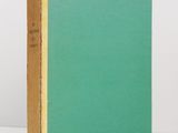 a green book sitting on top of a table next to a white wall