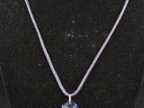 un gros plan d'un collier porté par un mannequin, orné d'une croix