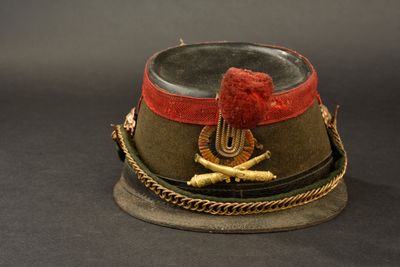 a military hat with a red ribbon on top of it