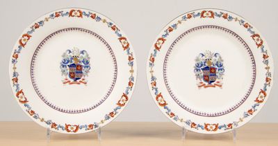 two plates with a coat of arms on them on a table