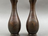 two brown vases sitting on top of a table next to each other