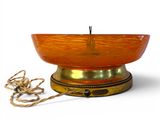 an orange bowl with a rope around it on a white surface