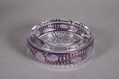 a clear glass ashtray with purple designs on it