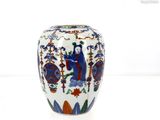 un vase blanc orné d'un motif bleu et rouge