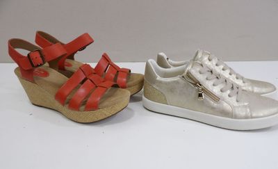 deux paires de chaussures argentées et rouges posées sur une surface blanche