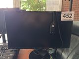 a computer monitor sitting on a desk next to a keyboard