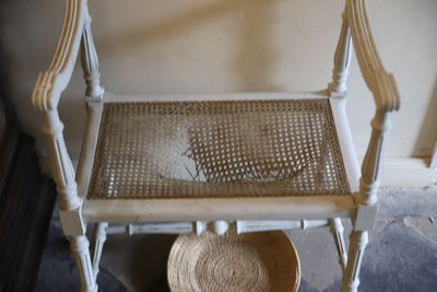 une chaise en osier avec un panier en dessous