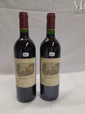 two bottles of red wine sitting on top of a white table
