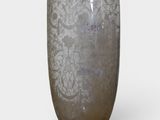 a glass vase with a pattern on it sitting on a table