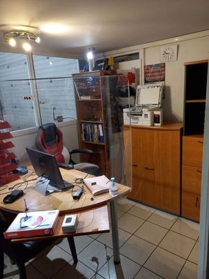 un bureau sur lequel se trouve un ordinateur portable, dans un coin de la pièce