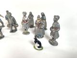 many figurines of different sizes and colors on a white surface