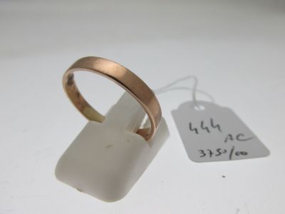 une bague à laquelle est accrochée une étiquette, posée à côté d'une étiquette