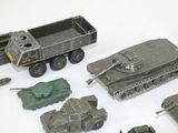 many toy military vehicles and trucks on a white surface