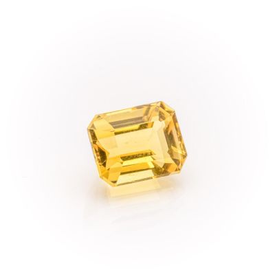 a yellow sapphire stone on a white background