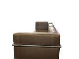 the back of a brown leather couch sitting on top of a white floor