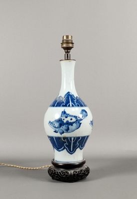 une photo d'un vase bleu et blanc avec une chaîne, posé sur une table