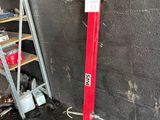 a red pipe sticking out of a wall next to a ladder