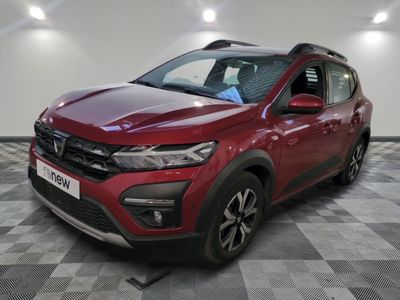 une voiture rouge garée dans un garage au sol en damier