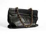a black leather handbag with a gold chain strap
