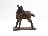 bronze statue of a goat on a wooden base on a white background