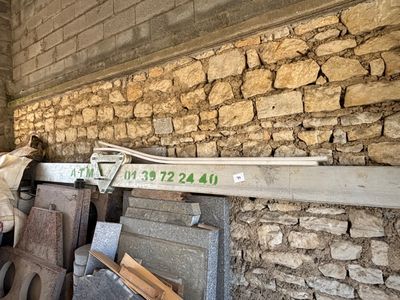 un tas de vieilleries devant un mur de briques