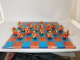 many figurines on a chess board on a table