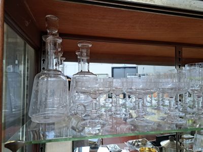 des bouteilles et des verres posés sur une étagère en verre dans un placard