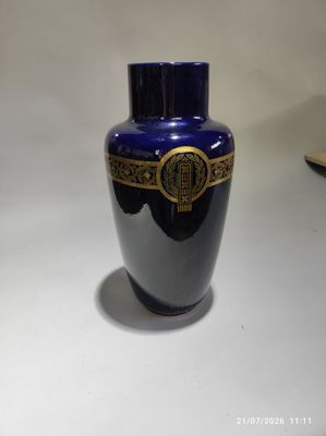 un vase bleu posé sur une table, avec un livre devant