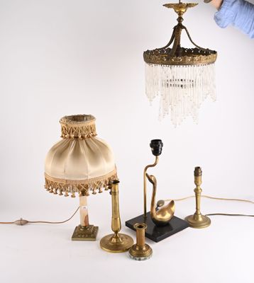 une personne tenant une lampe et un abat-jour posés sur une table