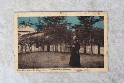 une vieille photo d'une femme debout dans un jardin