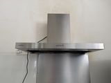 a stainless steel range hood in a kitchen with a heater on it