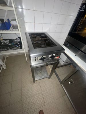 une cuisine équipée d'une cuisinière, d'un four et d'étagères