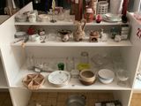une armoire blanche sur laquelle sont posés de nombreux plats et bols