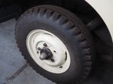 a white truck that has a tire on the side of the road