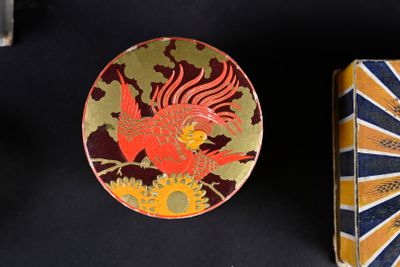 two tins with designs on them sitting next to each other