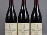 trois bouteilles de vin sont alignées sur une table