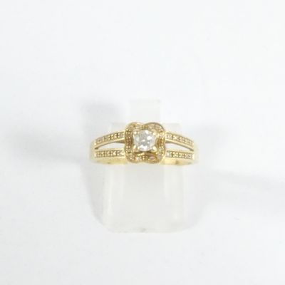 gros plan d'une bague en or avec un diamant au centre