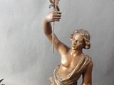a statue of a woman holding a spear and a fish