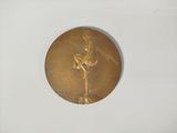 une image montrant un gros plan d'une médaille d'or posée sur une surface blanche