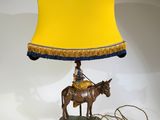 une lampe sur laquelle est représenté un cheval, avec un abat-jour jaune