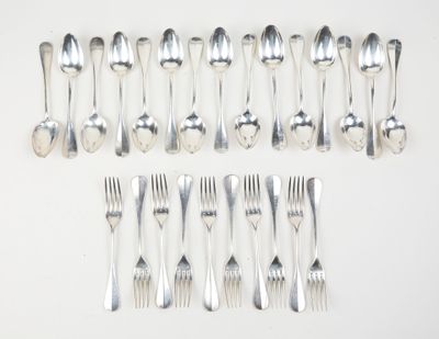 many forks and spoons laid out on the table
