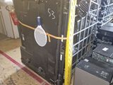a large black refrigerator in a room with a rack of electronics