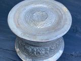 une assiette en argent posée sur une table en bois, sur fond bleu